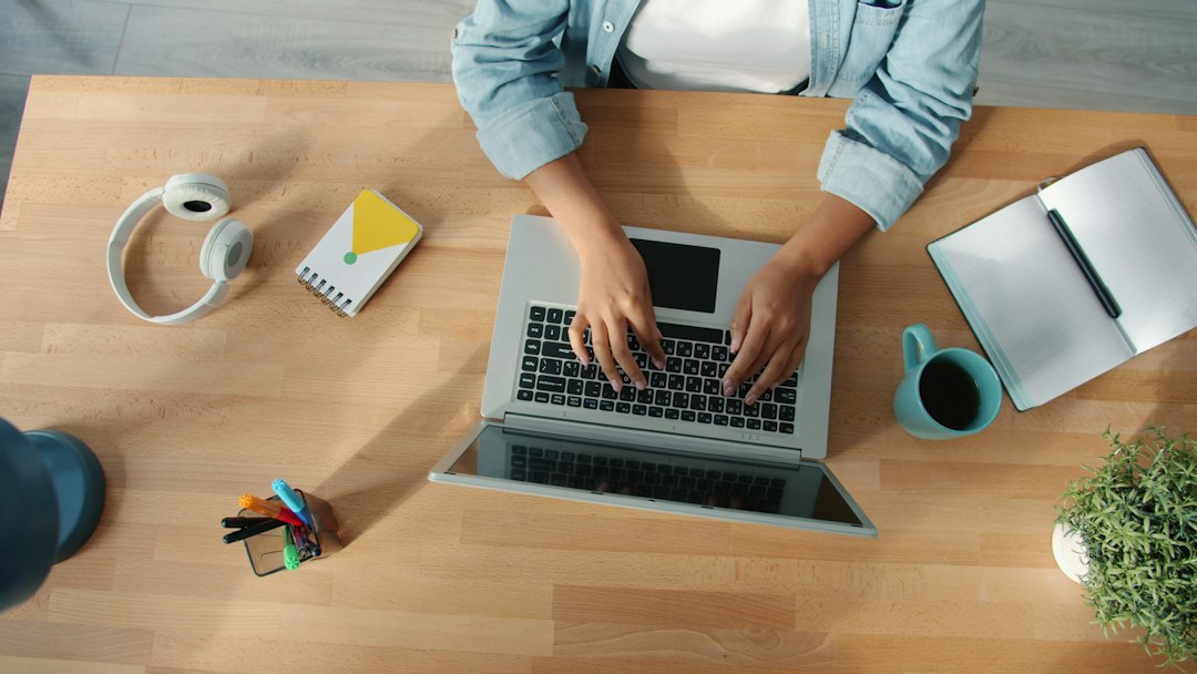 about-us female freelancer typing working with laptop at wooden desk concentrated on activity. Modern devices and internet work concept.